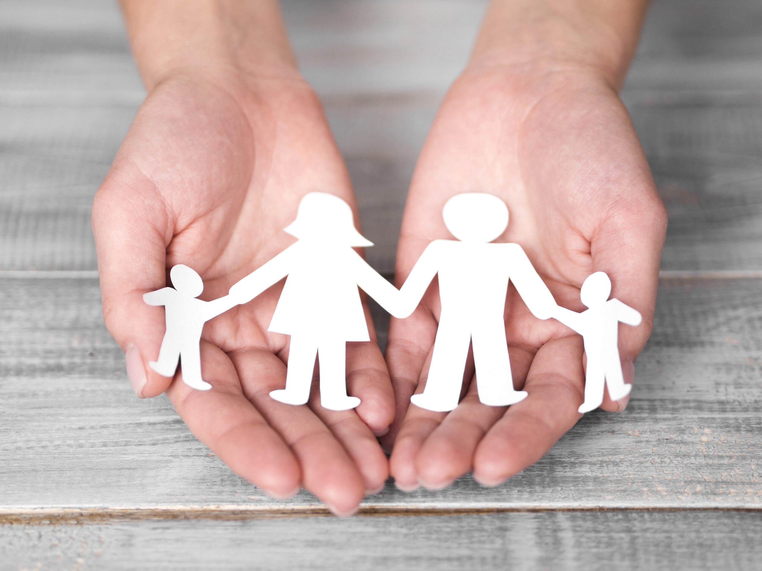 Mani che tengono silhouette di famiglia realizzata in carta